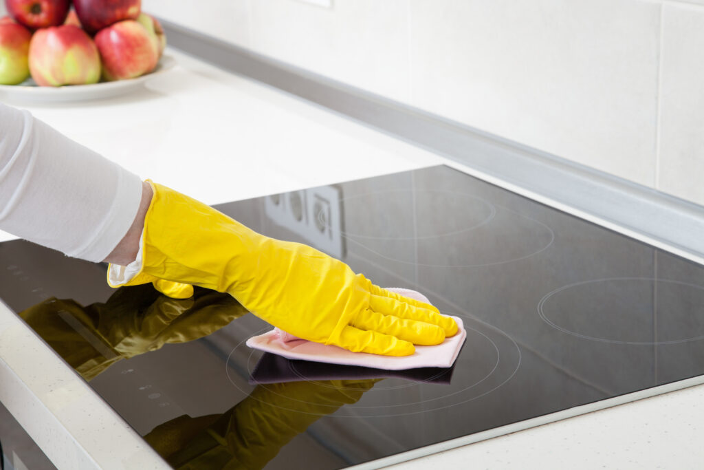 Housewife cleaning an induction plate, closeup shot