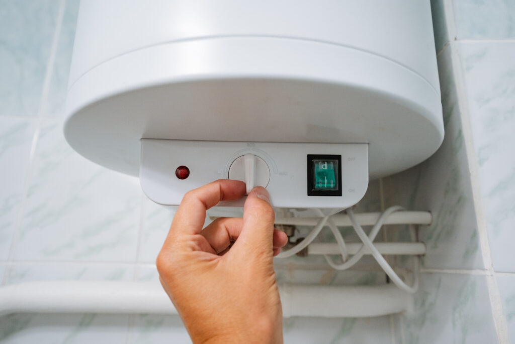 A person is actively turning on the water heater located in their bathroom, which is an essential home appliance for providing hot water needed for various everyday tasks and activities