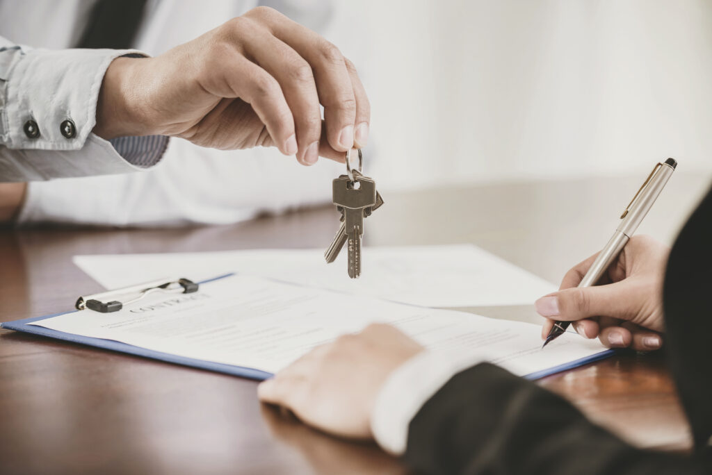 Young woman is signing financial contract with male realtor. Close-up.