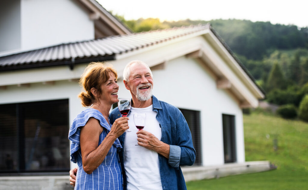 Portrait of senior couple with wine outdoors in backyard. Copy space.