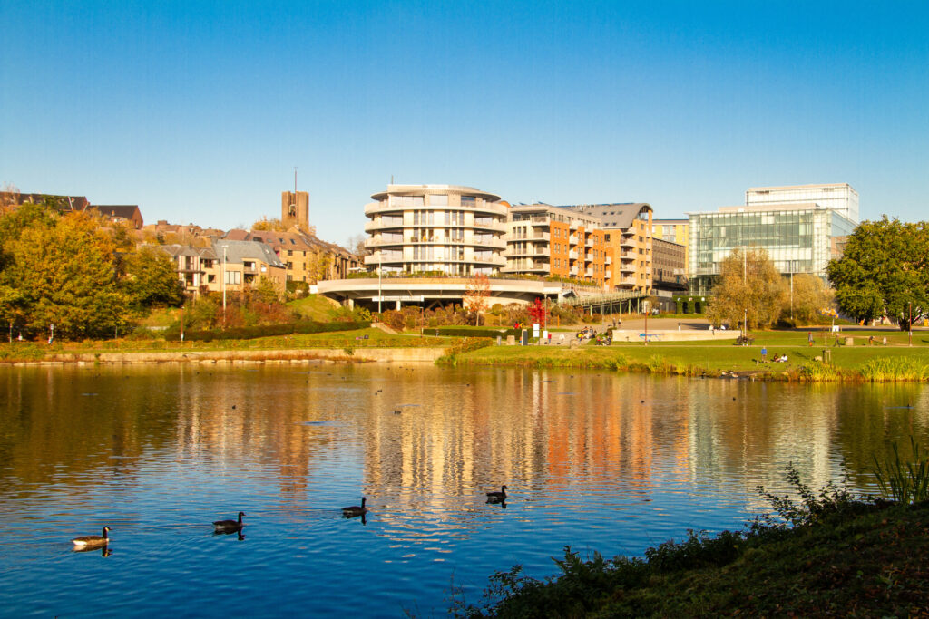 View of Louvain-La Neuve with the Aula Magna from the lake. The Belgian municipality of Ottignies-Louvain-la-Neuve, located in the Walloon Region in the province of Walloon Brabant. Lake Louvain-la-Neuve is an artificial lake. The Aula Magna is the performance hall.