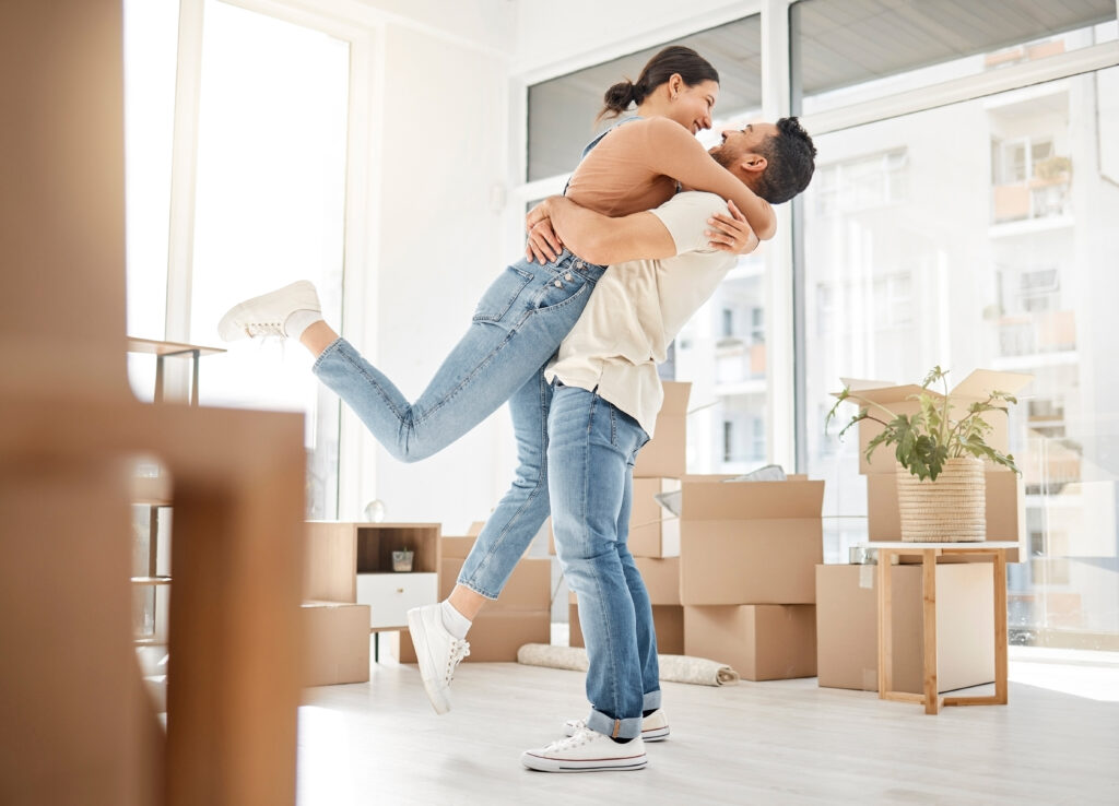 Love, moving and hug with couple in new home for celebration, property and relocation. Excited, happy and real estate with man and woman in living room apartment for investment, rent and homeowner.