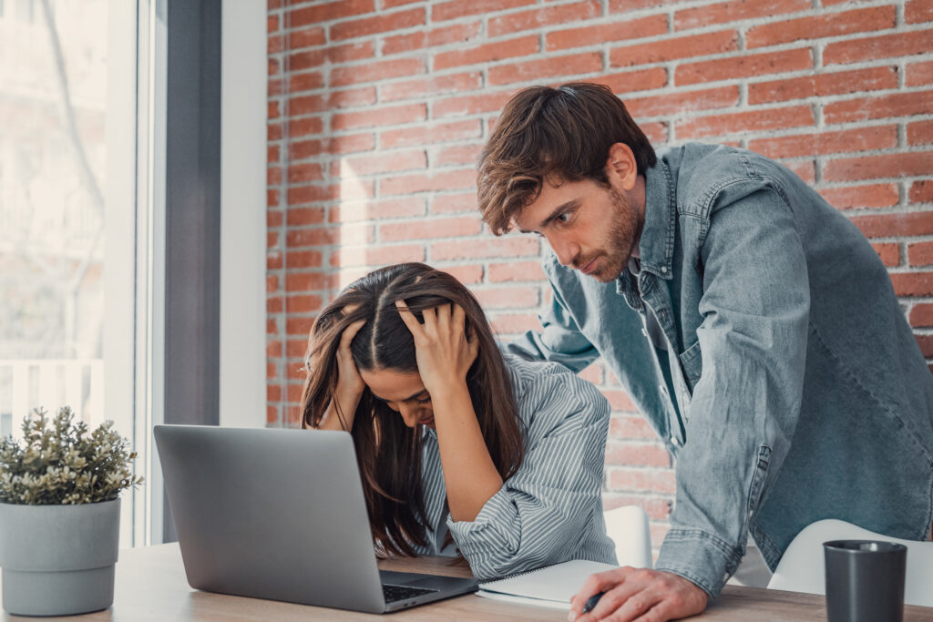 Mad millennial couple frustrated with slow Internet connection paying bills online at home, confused young husband and wife angry with unexpected error mistake using internet banking on computer